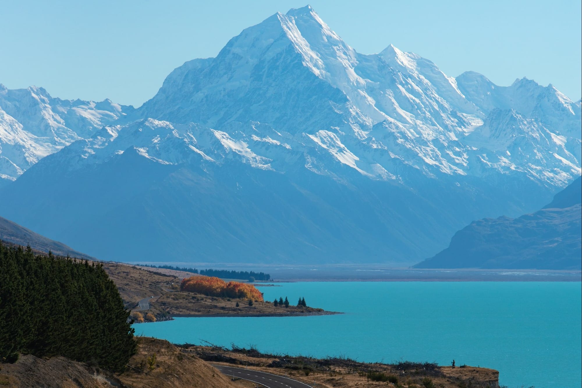 snow covered mountain near body of water during daytime