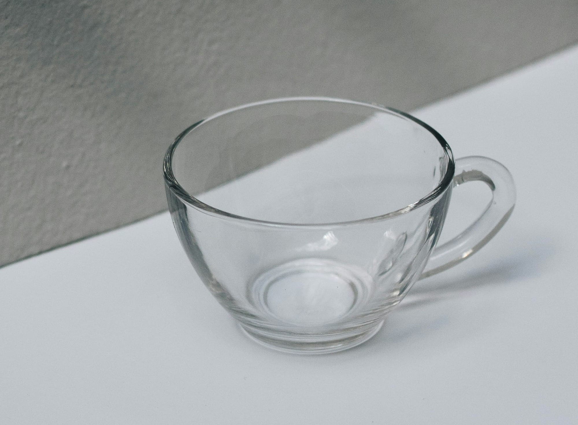 clear glass cup on white table