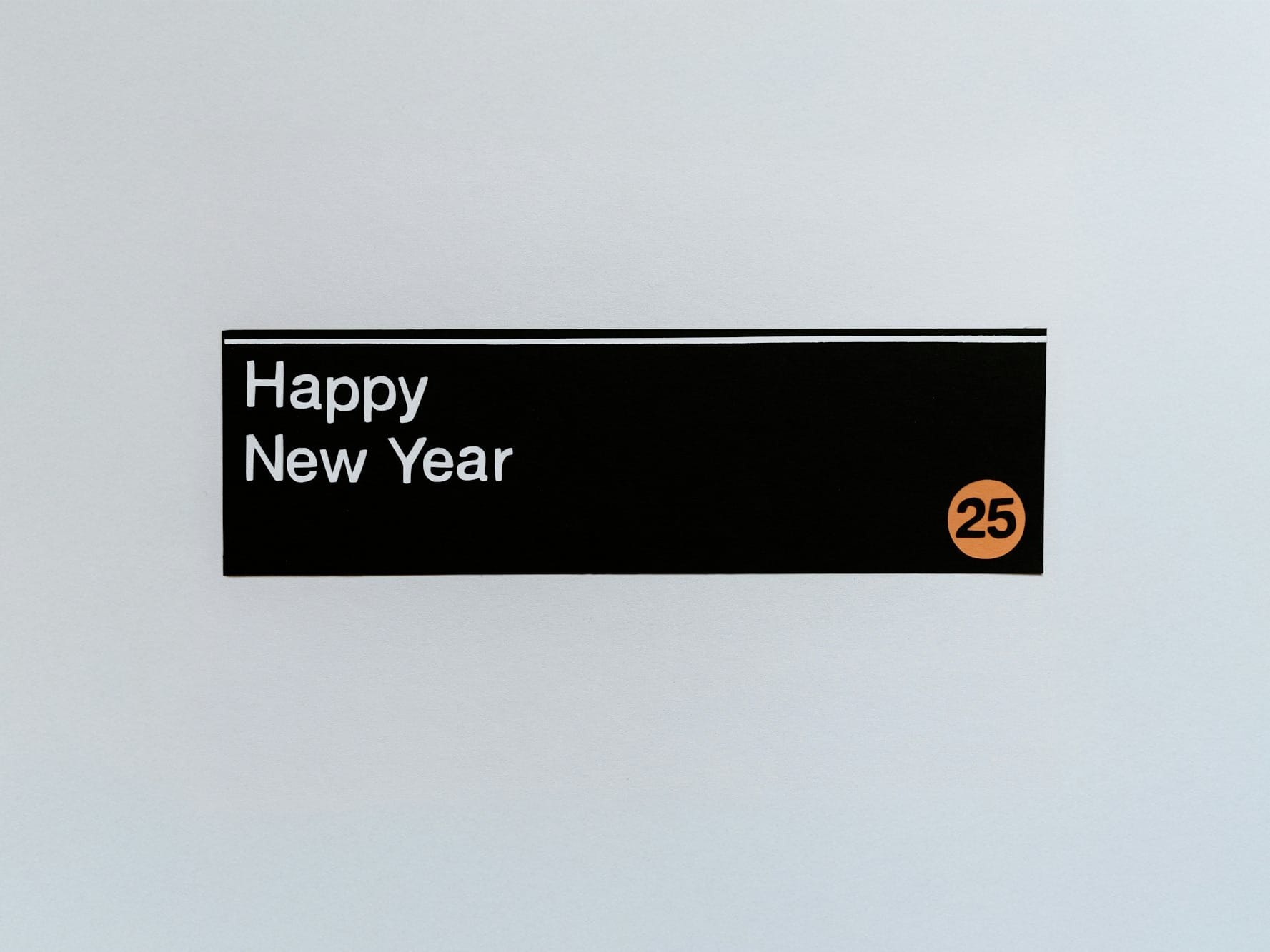 A sign that says happy new year hanging on a wall